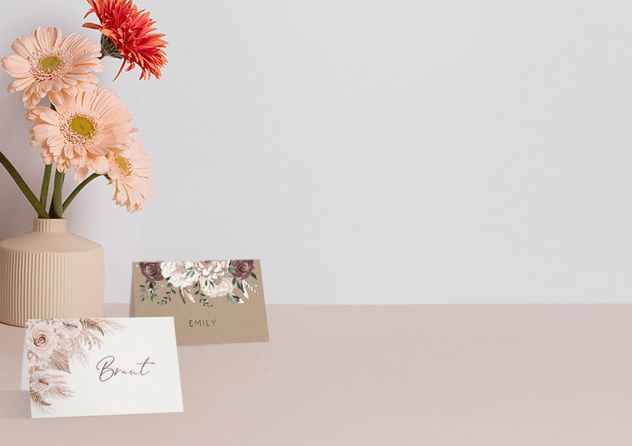 zwei aufgeklappte Tischkarten in zwei verschiedenen, floralen Hochzeits-Designs