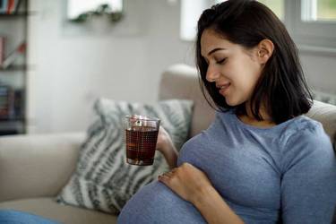 Schwangere trinkt Tee gegen Schwangerschaftsübelkeit
