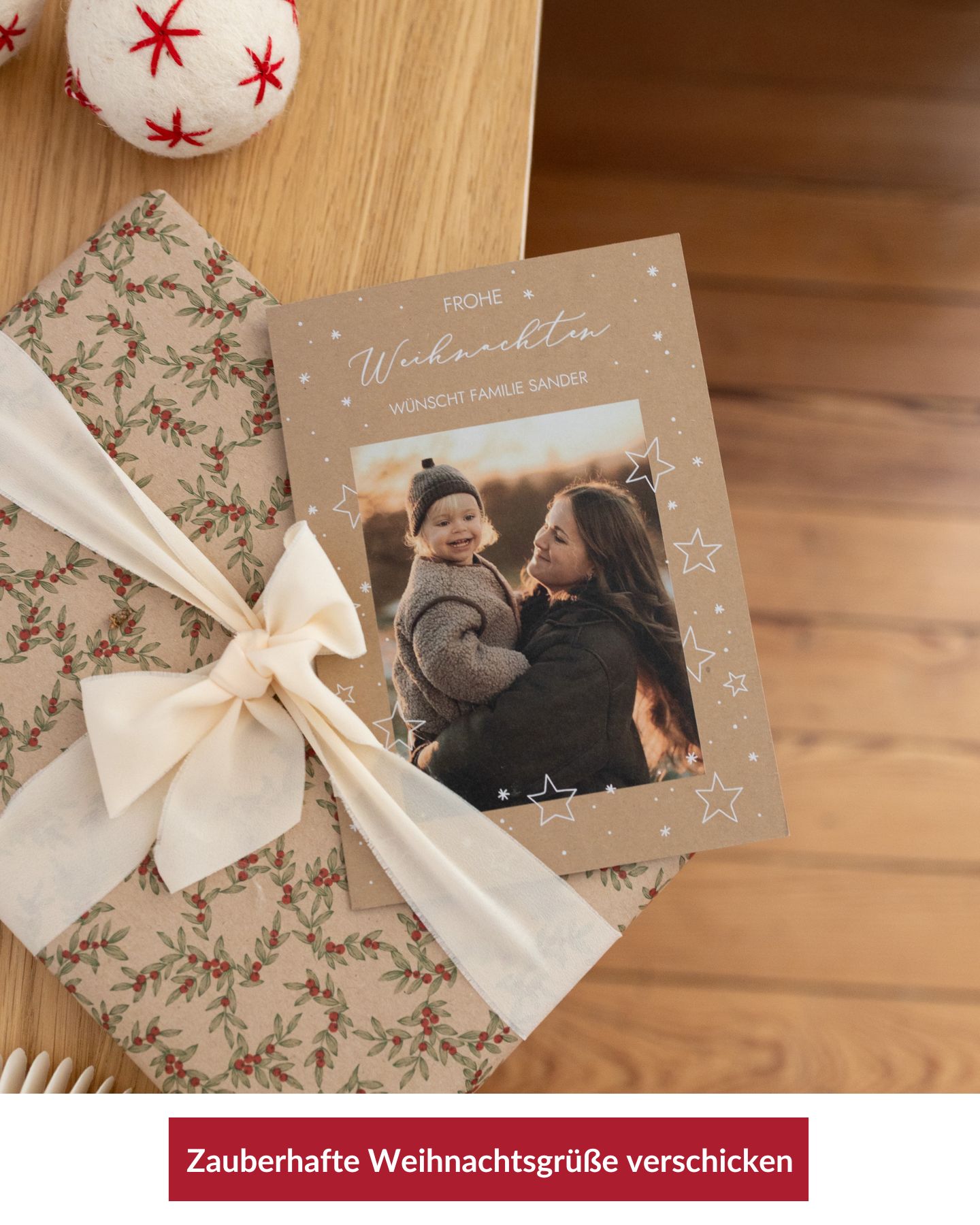 Weihnachtskarte auf einem Tisch mit Geschenk und Weihnachtskugel