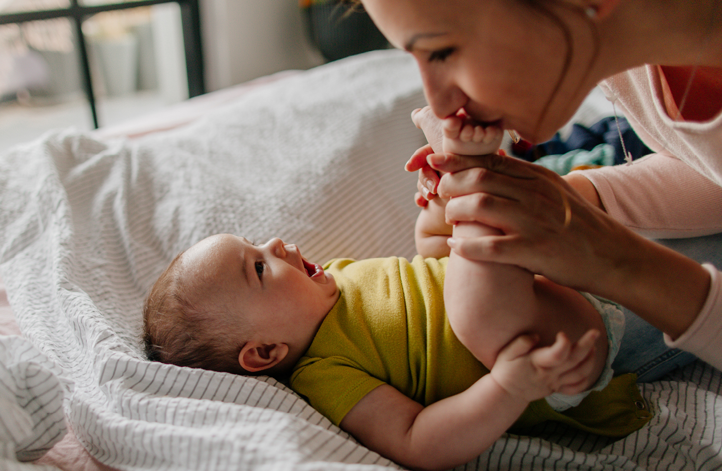 Baby mit französischem Mädchennamen kuschelt sich in den Arm der Mutter