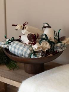 Adventskalender aus mit Stoff eingeschlagenen Klorollen in einer Holzschale