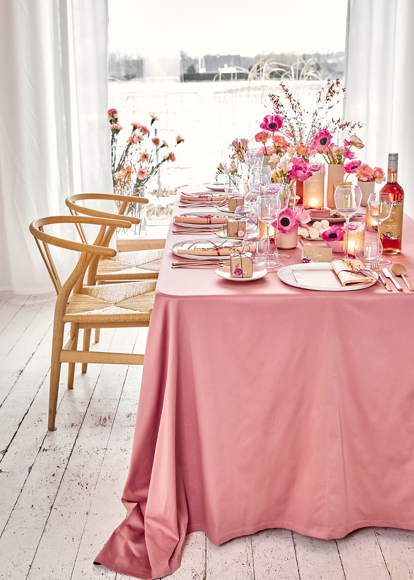 Tischdeko Hochzeit: Hochzeitstisch in vielen Pinktönen, mit geflochtenen hellbraunen Stühlen in einer weißen Vintage-Location.