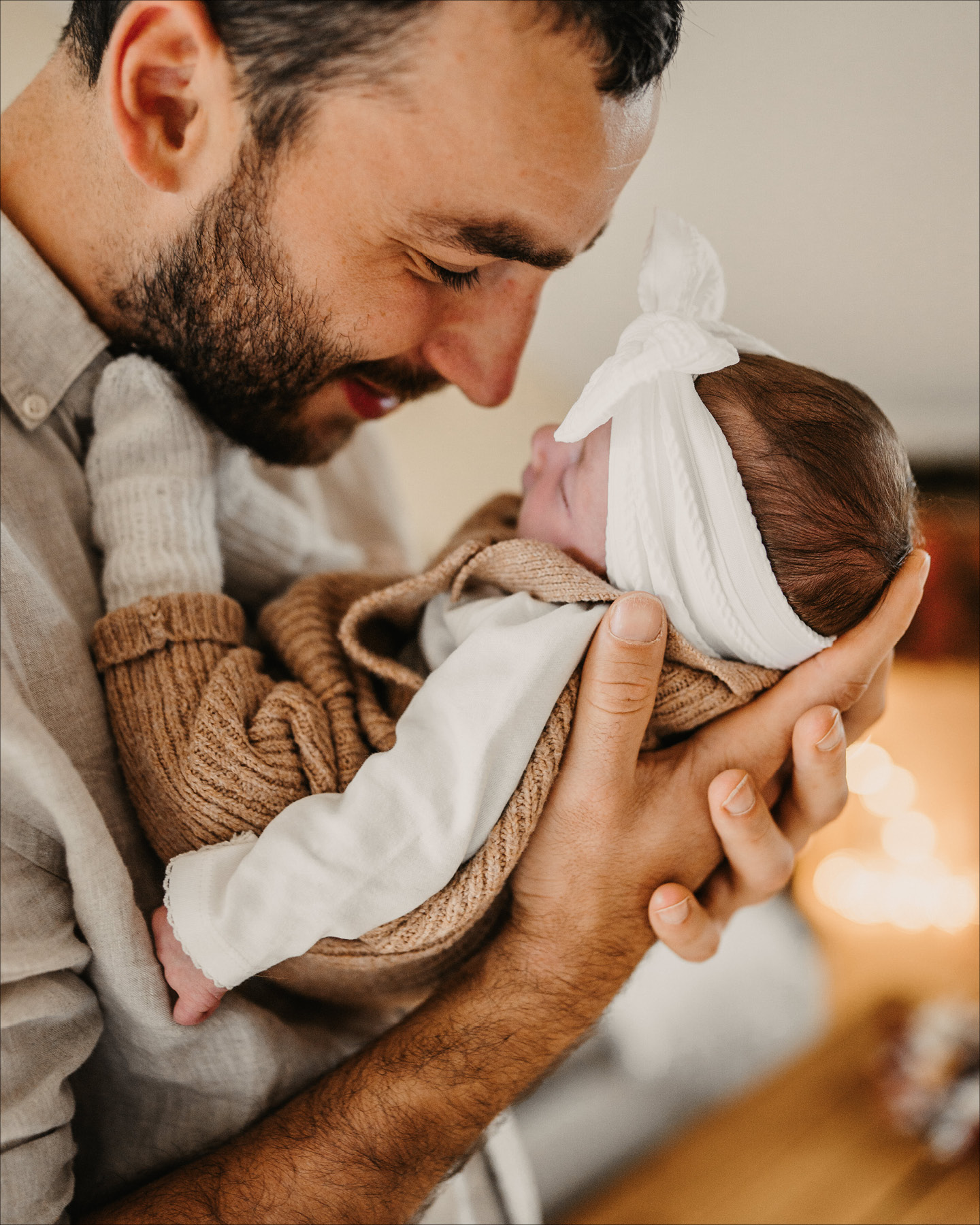 Glücklicher Vater hält sein Baby zärtlich auf dem Arm