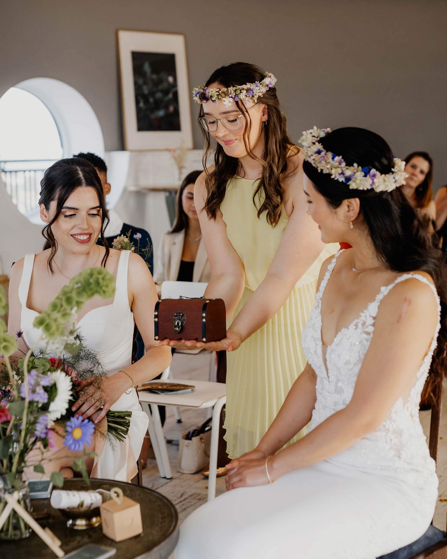 Trauzeugin bringt Eheringe in Holzschatulle zum Hochzeitspaar