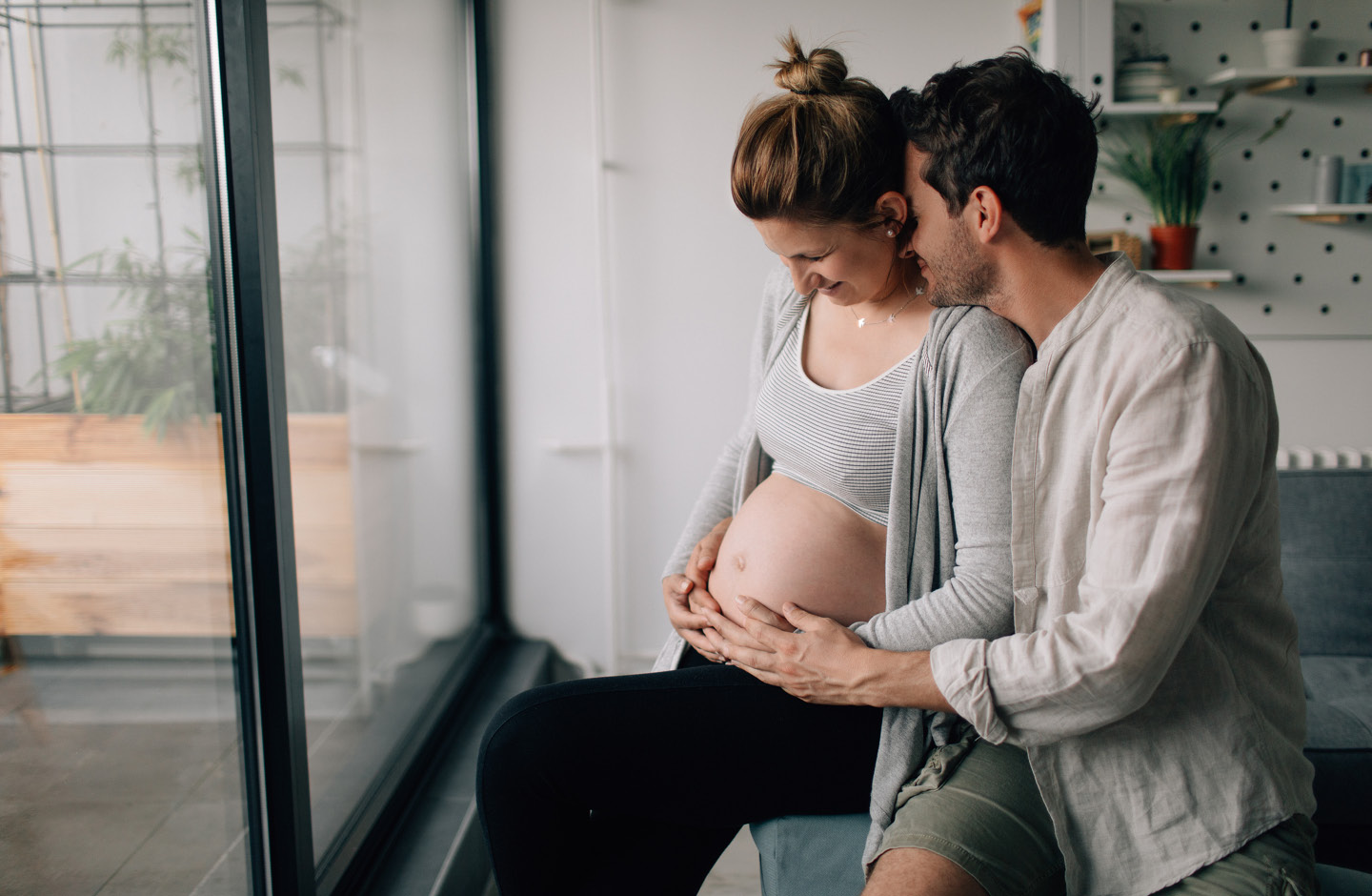 Mann umfasst zärtlich den Bauch seiner schwangeren Partnerin