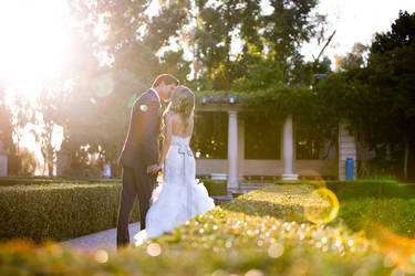 Portrait of a beautiful couple kissing on their wedding day. Sun flare.