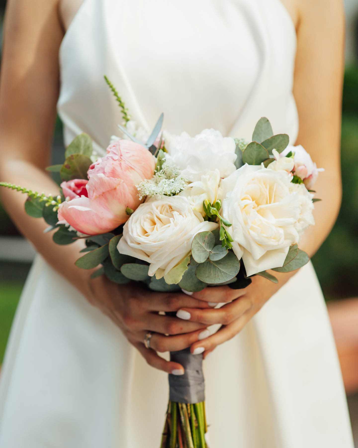 Braut hält Braustrauß aus weißen Pfingsrosen