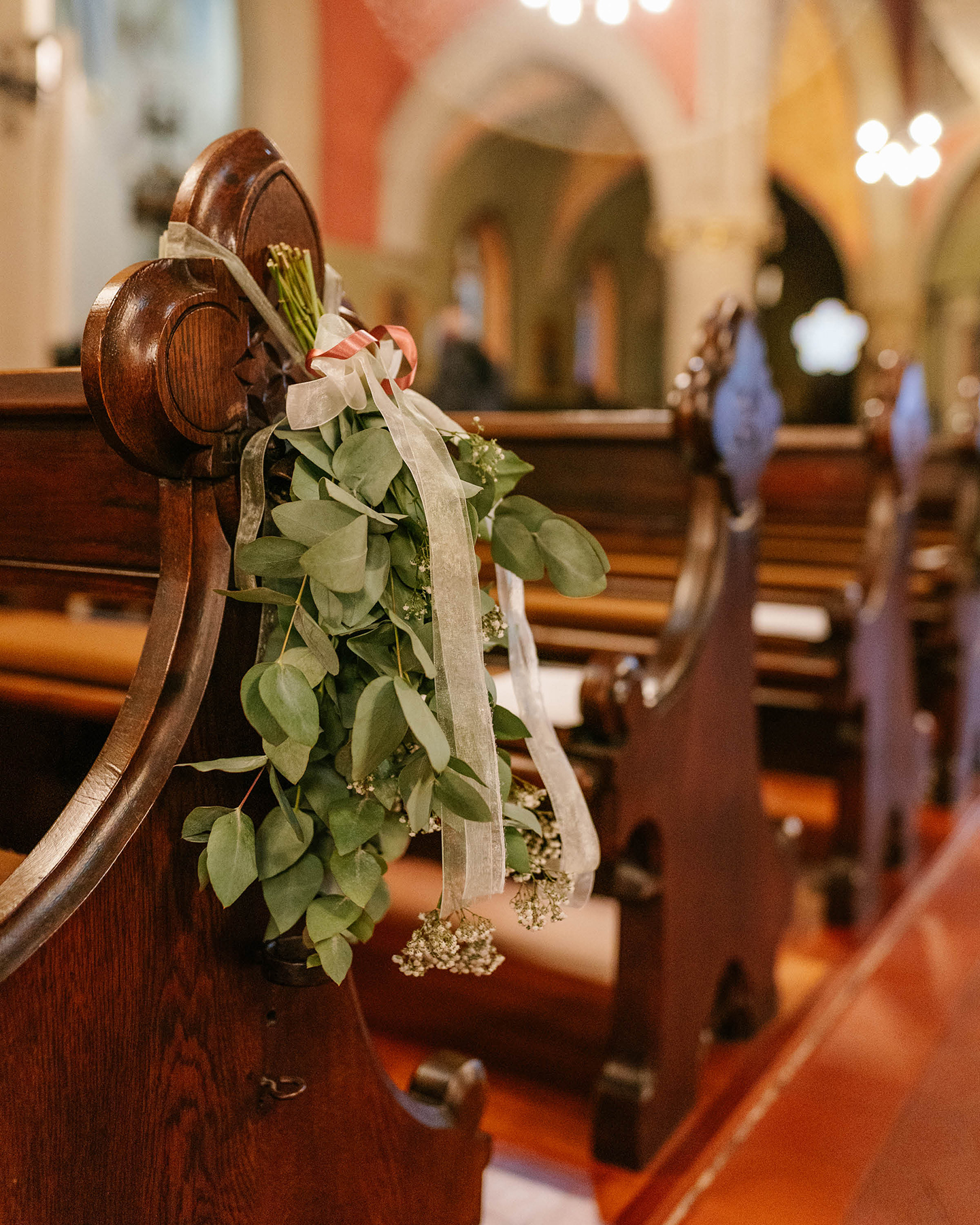 Detailaufnahme einer hochzeitlich geschmückten Kirchenbank.