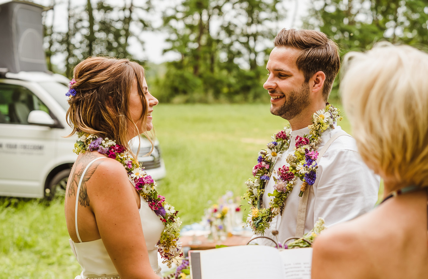 Hochzeitspaar hält sich bei der Camper Hochzeit an den Händen.