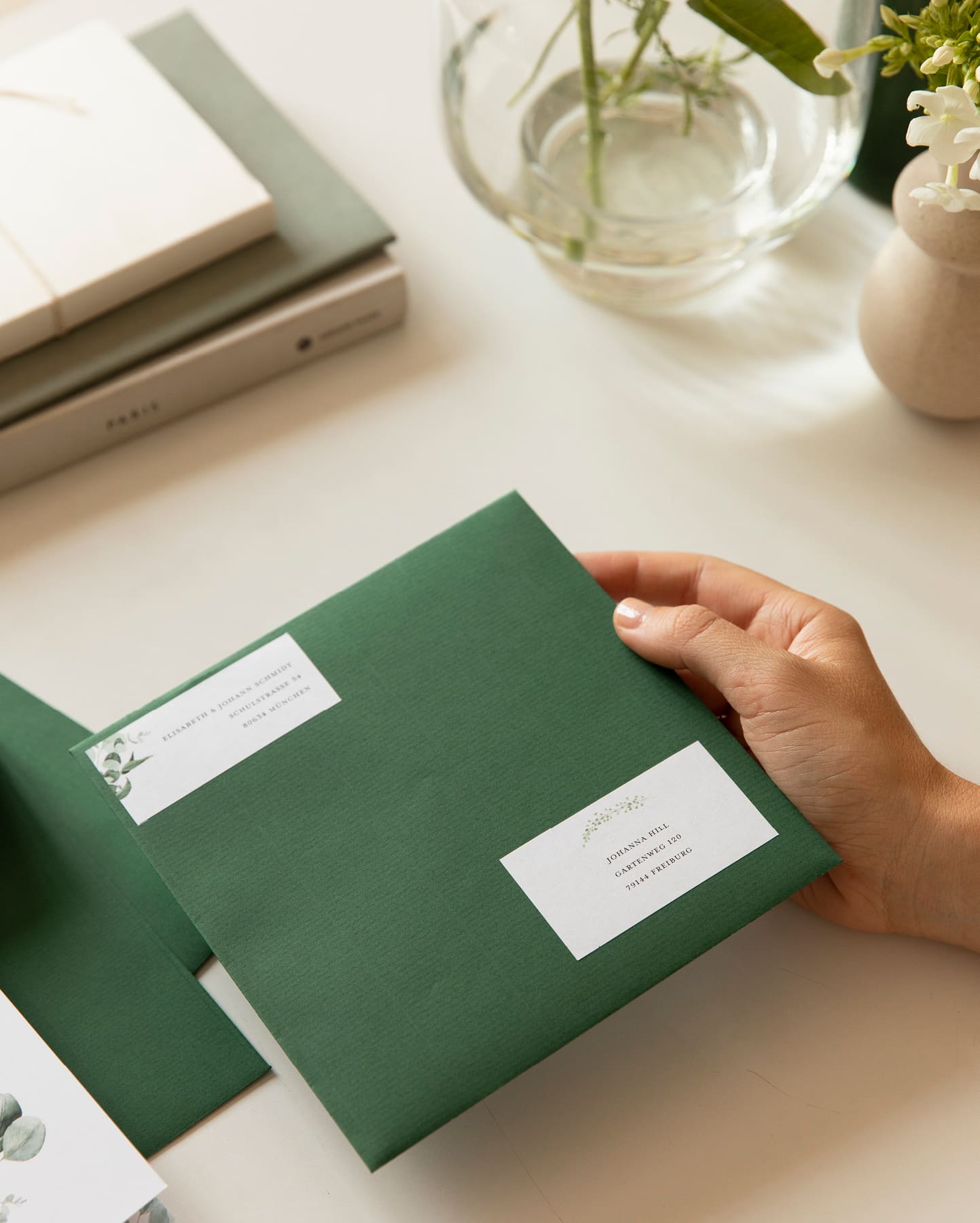 Quadratisches dunkelgrünes Kuvert mit Adress- und Empfängeraufklebern