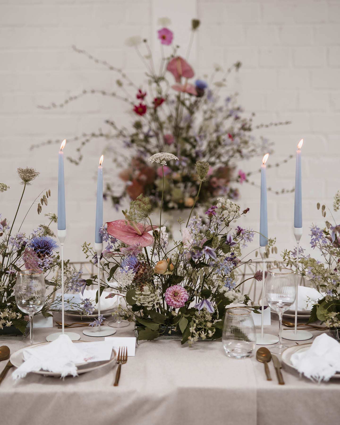 Ein weit gefächertes Blumenarrangement ist das Highlight auf der Hochzeitstafel
