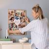 Junge Mutter hängt ihr Muttertagsgeschenk, eine gerahmte Cllage, an die Wand