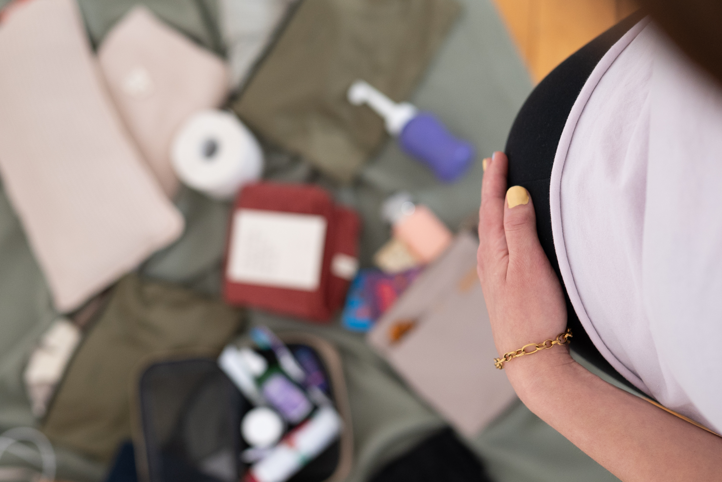 Schwangere auf der Couch mit gepackter Kliniktasche für die Geburt