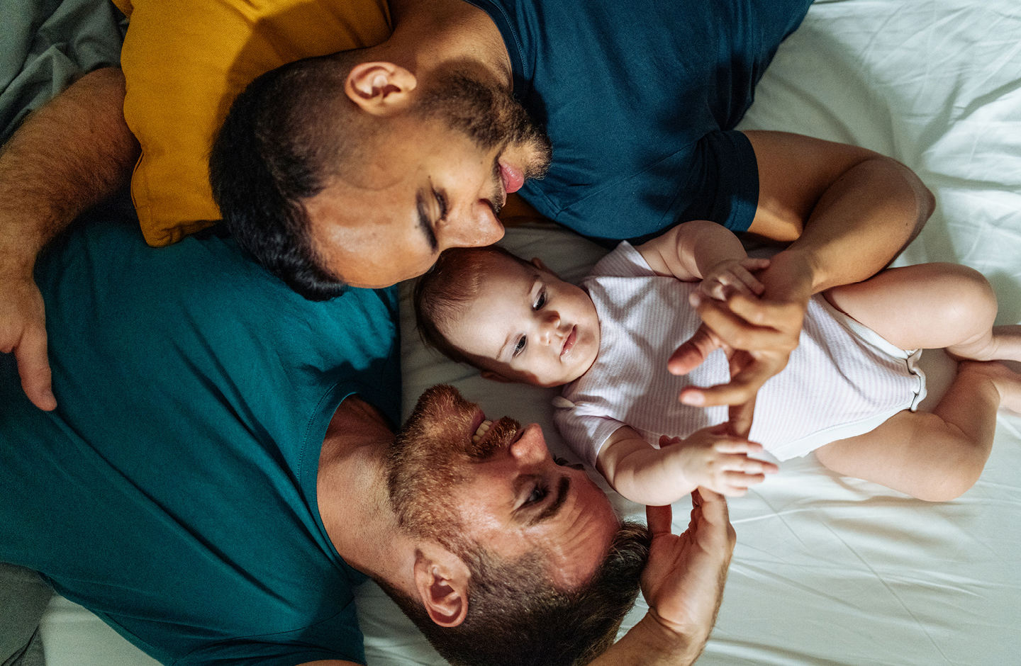 Zwei Papas kuscheln mit ihrer Tochter mit dem nordischen Mädchennamen "Siv"