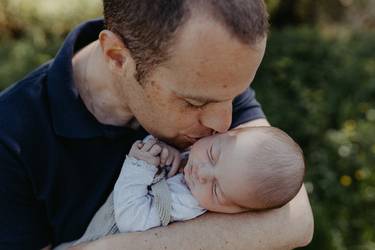 Zärtlicher Vater schmust mit seinem Baby auf dem Arm