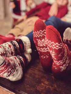 Familie mit Kuschelsocken auf dem Sofa in der Adventszeit