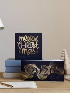 Ausgefallene WEihnachtskarten mit Veredelung auf einem Schreibtisch