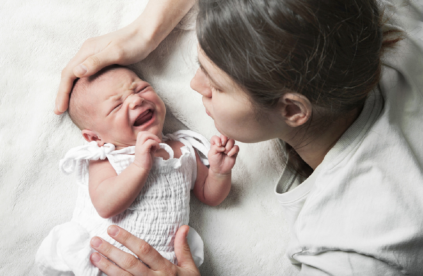 Mutter im Bett mit weinendem Baby