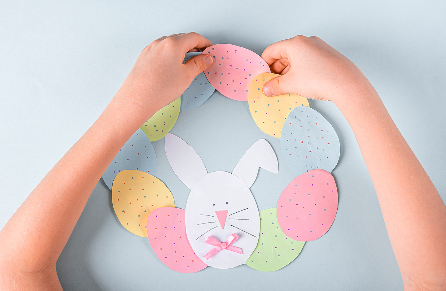 Basteln zu Ostern: Bunte Ostereier werden aus Papier ausgeschnitten und als Kranz zusammen geklebt.