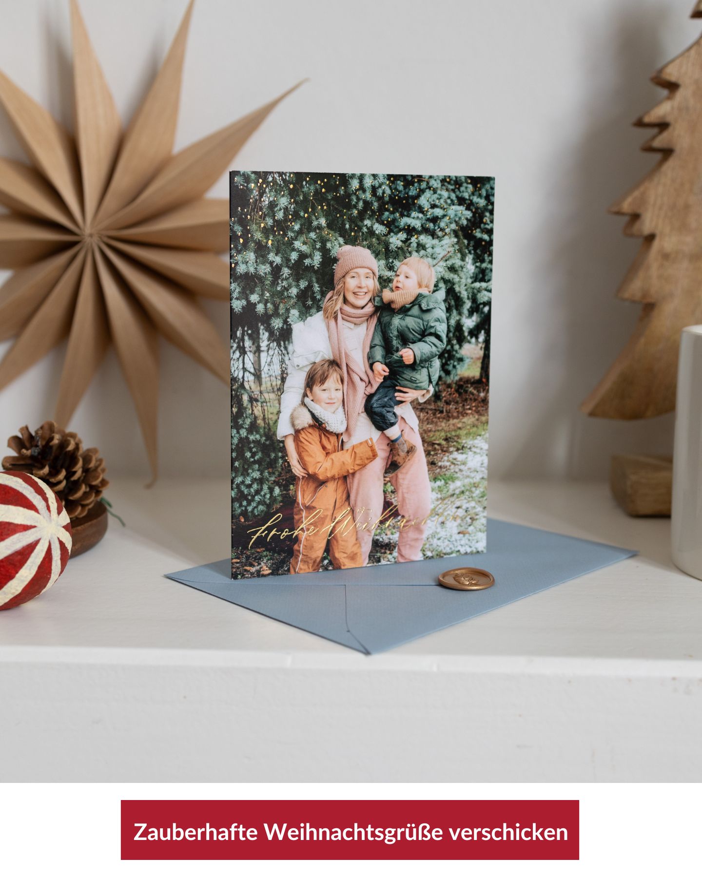 Foto-Weihnachtskarte mit Umschlag auf weihnachtlich dekoriertem Regal