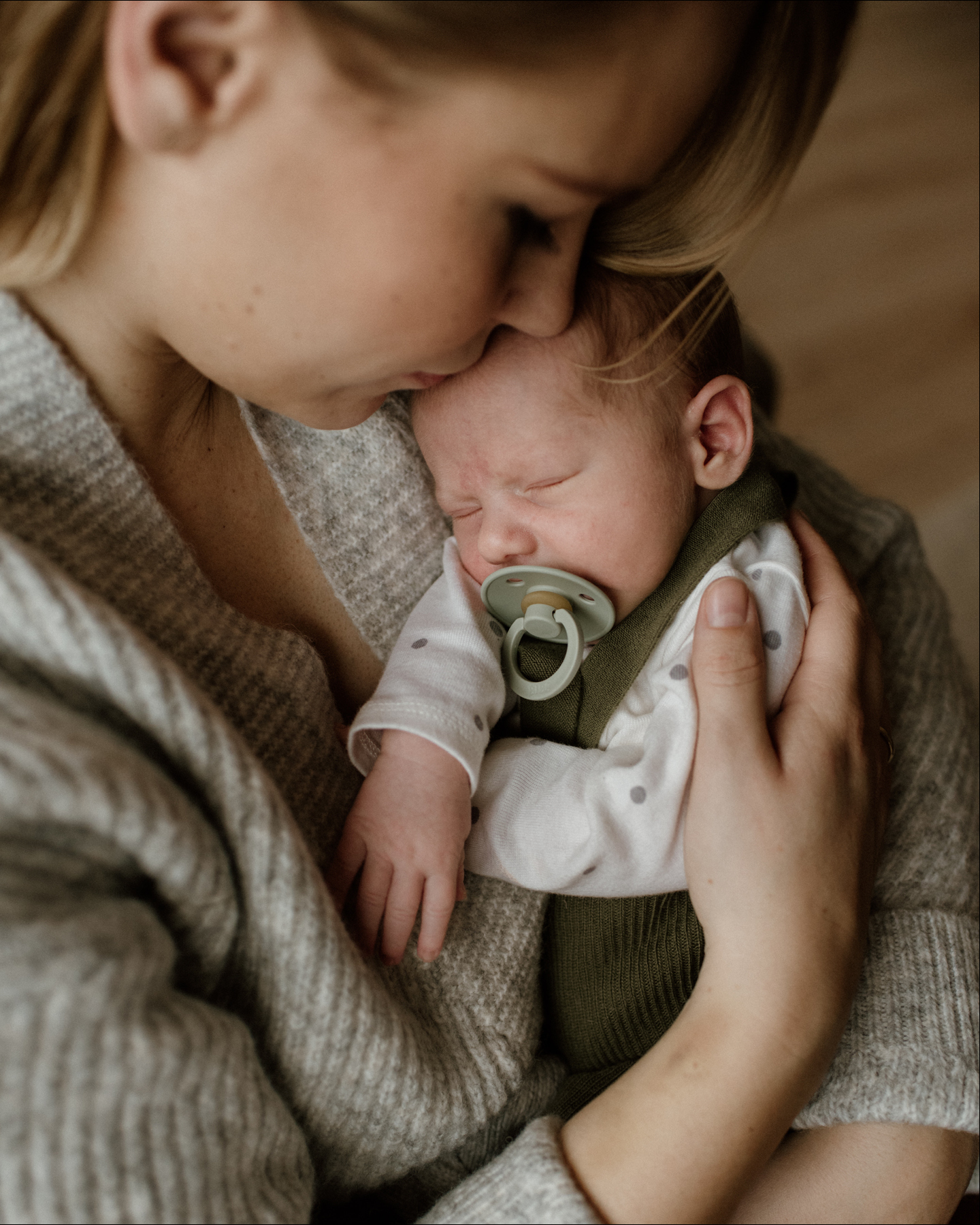 Baby schläft auf dem Arm seiner Mutter