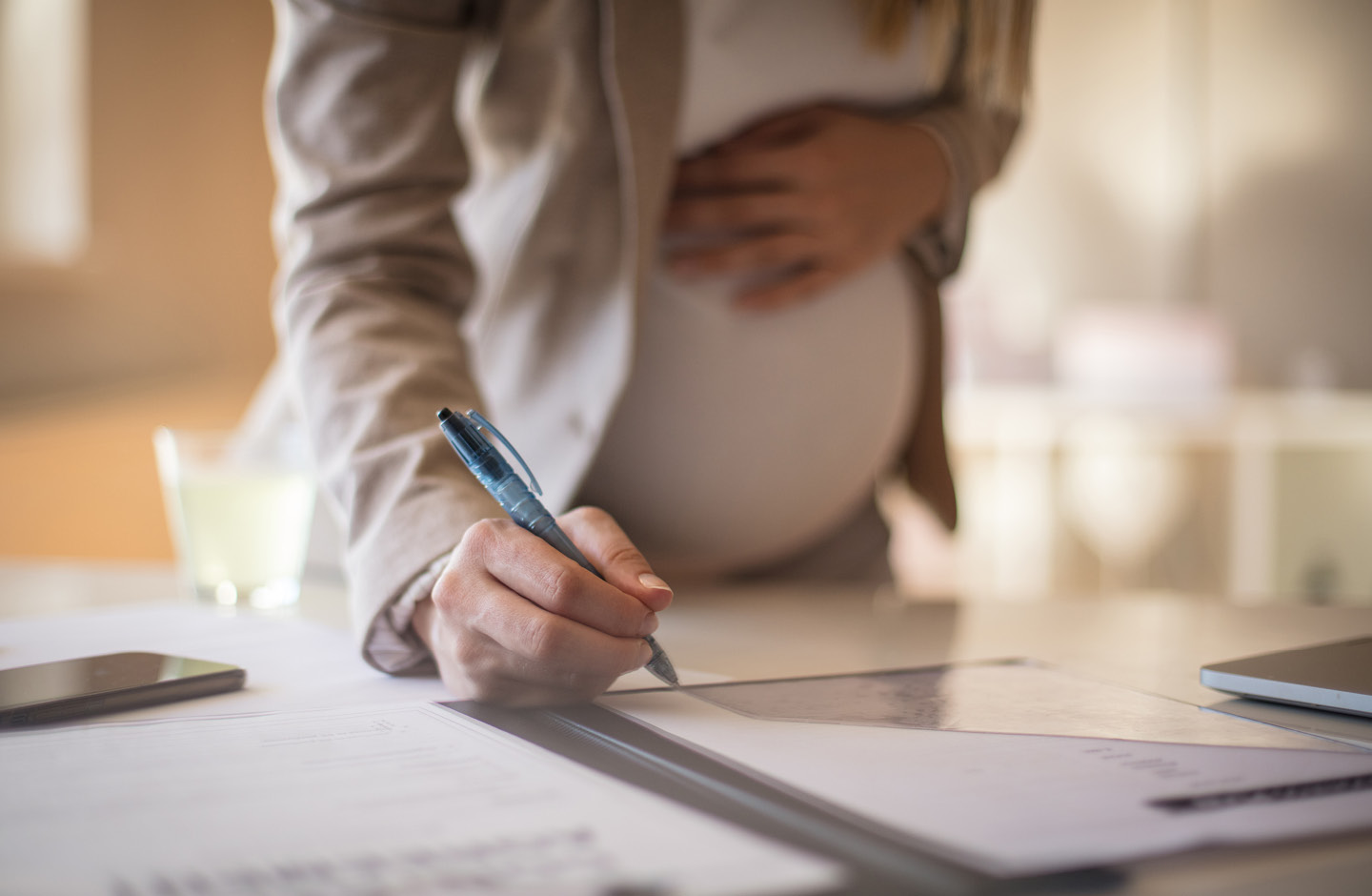 Schwangere unterschreibt ein Dokument