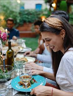 Gäste am Tisch bei einer bunt geschmückten Gartenparty