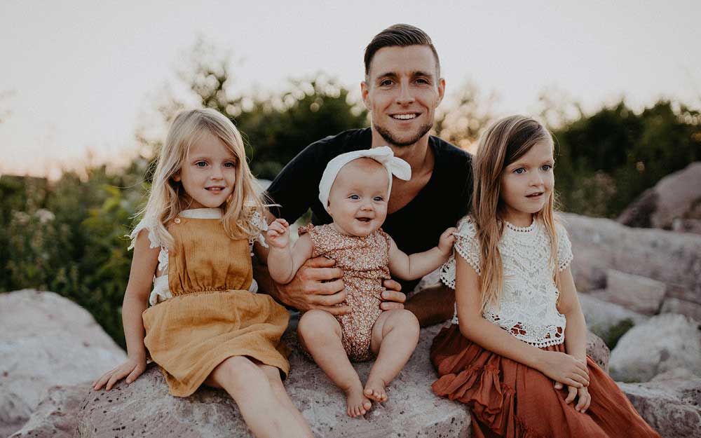 Vater mit seinen drei kleinen Töchtern im Freien