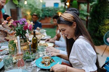 Gäste am Tisch bei einer bunt geschmückten Gartenparty