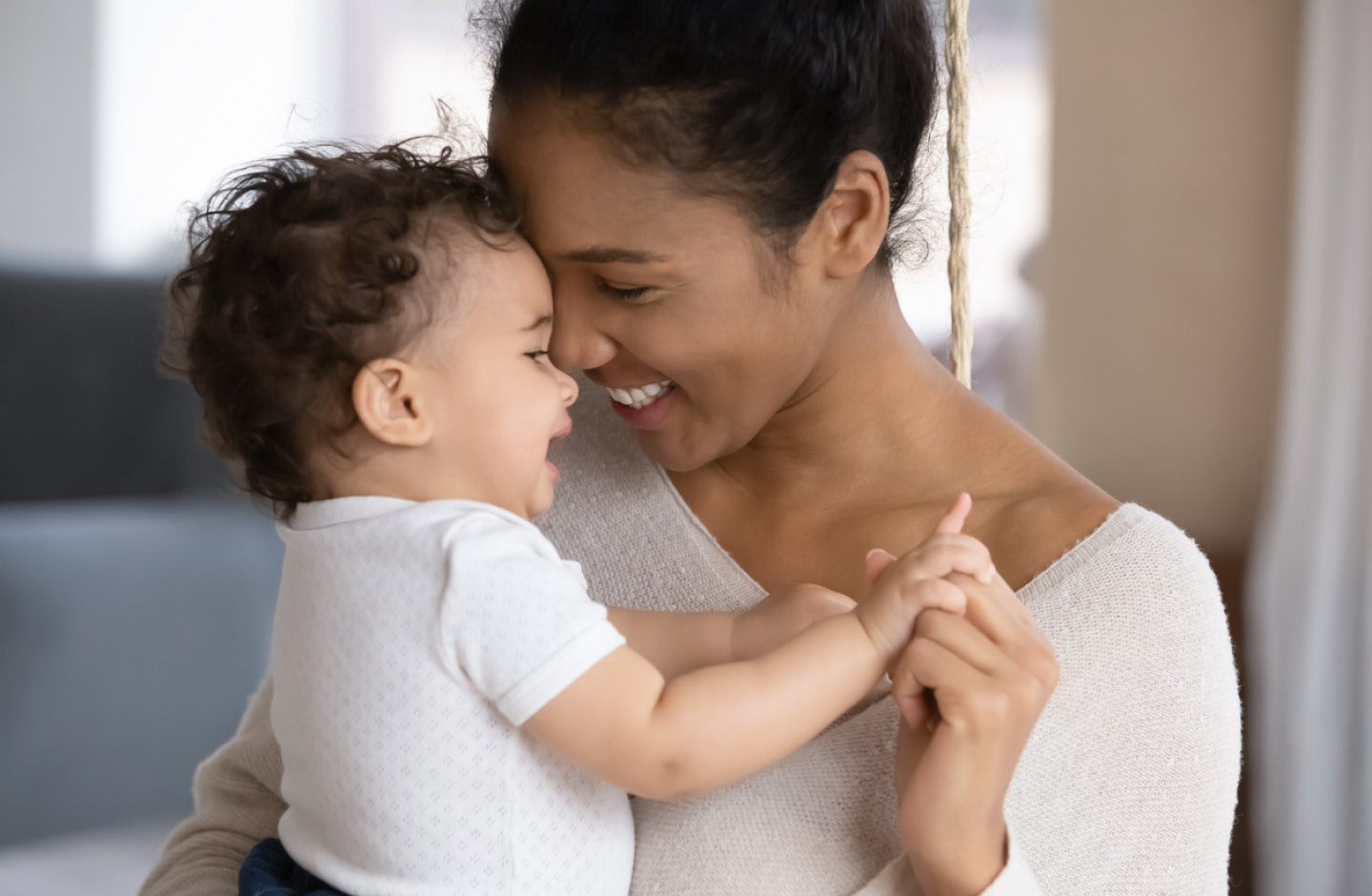 Glückliche Mutter strahlt und umarmt ihr Baby mit französischem Mädchennamen