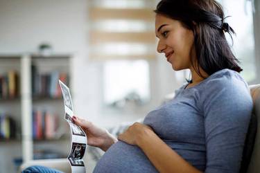 Schwangere Frau sieht sich Ultraschallbilder an