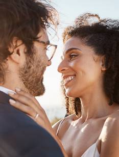 Glückliches Hochzeitspaar lächselt sich an