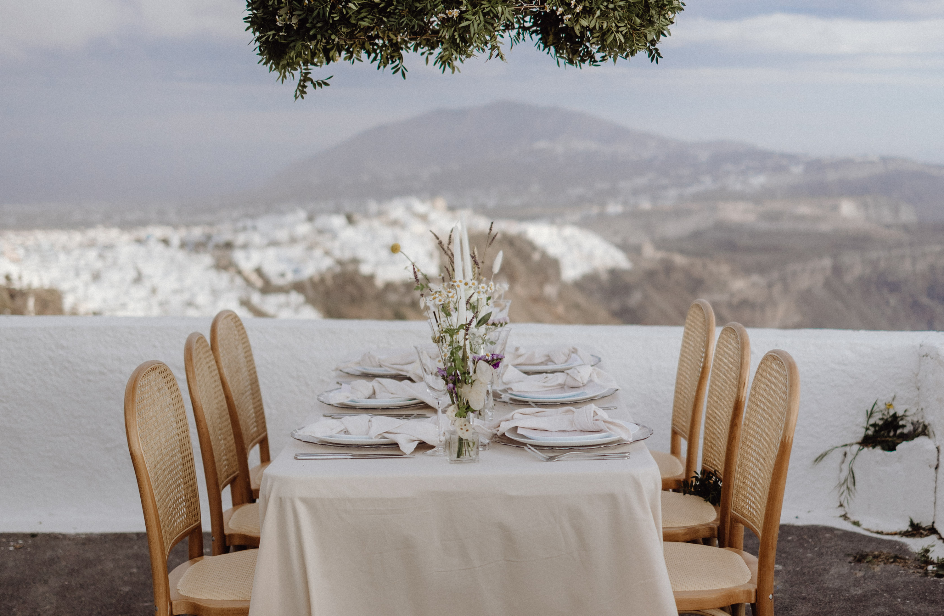 Der Hochzeitstisch ist dekoriert und bietet Ausblick auf die Stadt Fira in Santorini.