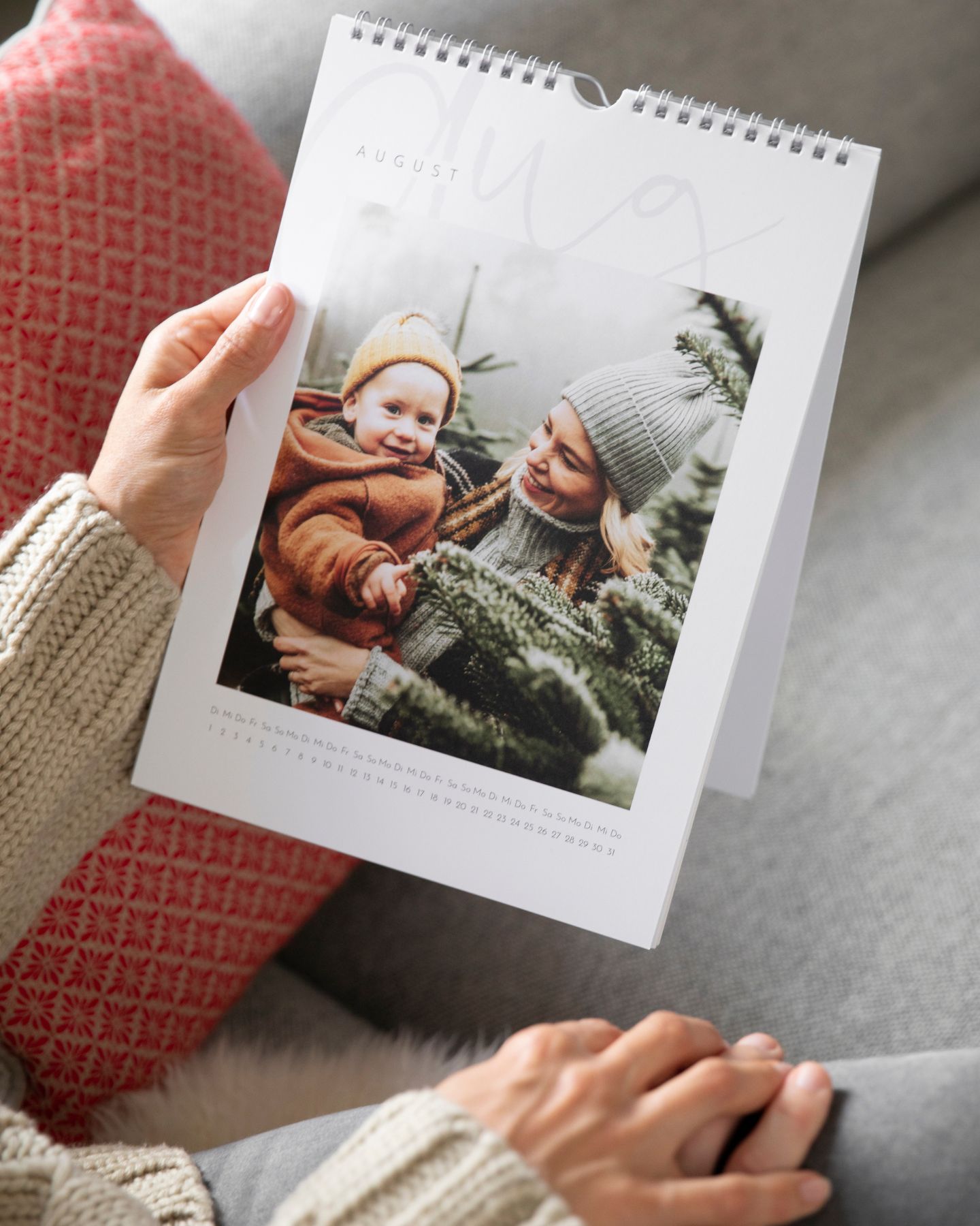 Ein Fotokalender wird von einer Frau in der Hand gehalten.