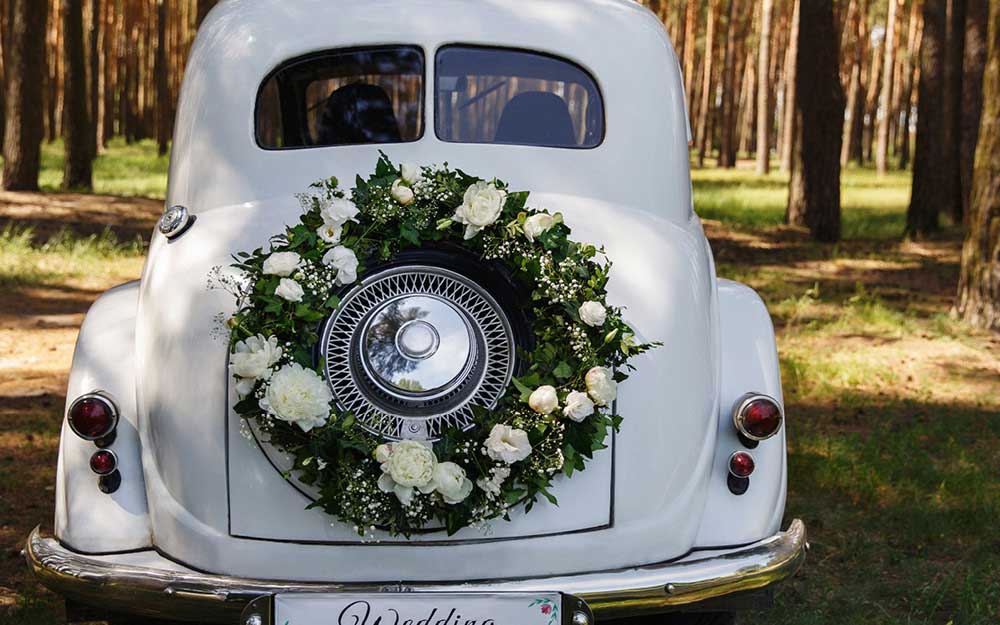 Auto mit Blumenkranz für die Hochzeit