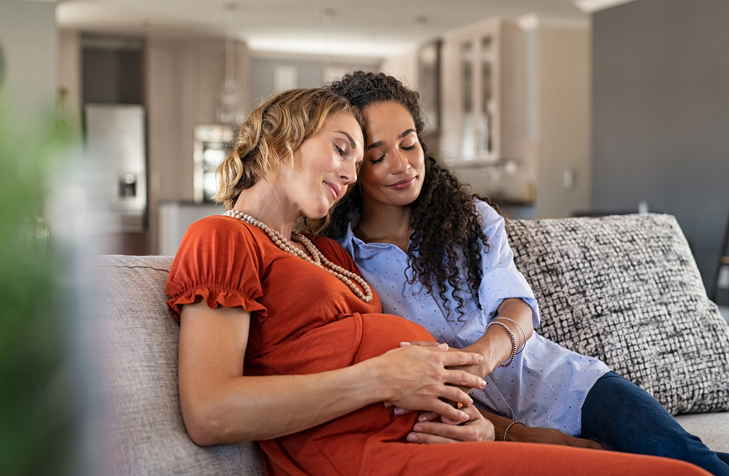 Zwei Mamas streicheln liebevoll den runden Babybauch.