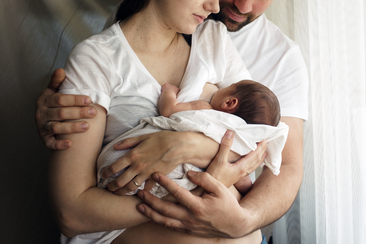 Eltern kuscheln mit ihrem Baby mit spanischem Mädchennamen auf der Couchauf d