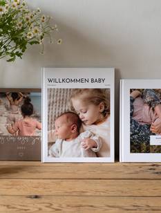 Drei Fotobücher auf einer Kommode nebeneinander aufgestellt
