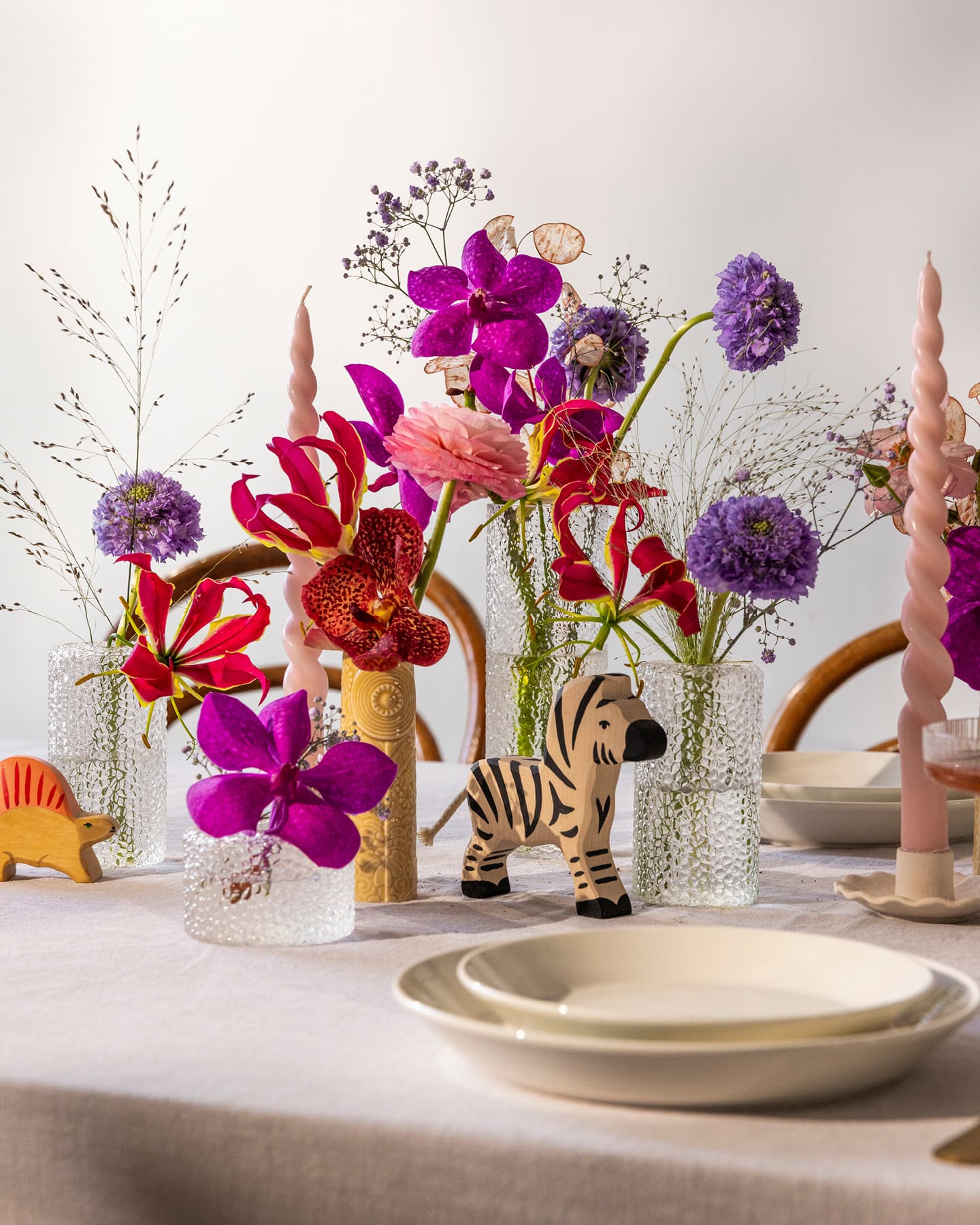 Zur Taufe geschmückte Tafel mit bunten Blüte in Glasvasen