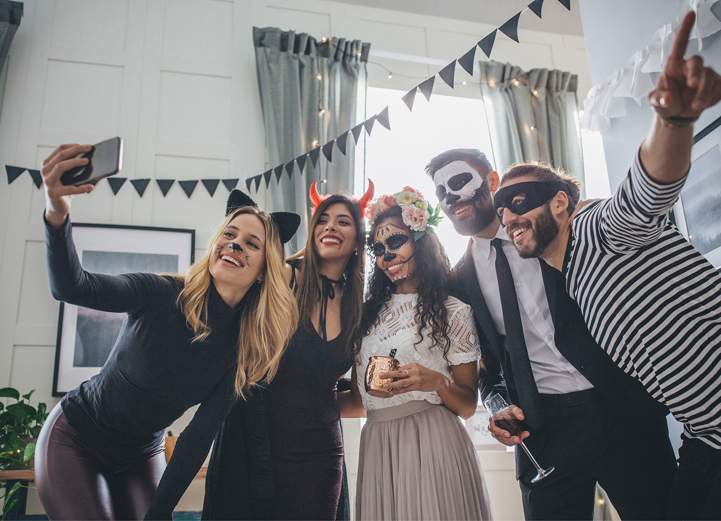 Freunde feiern Halloween in gruseligen Kostümen