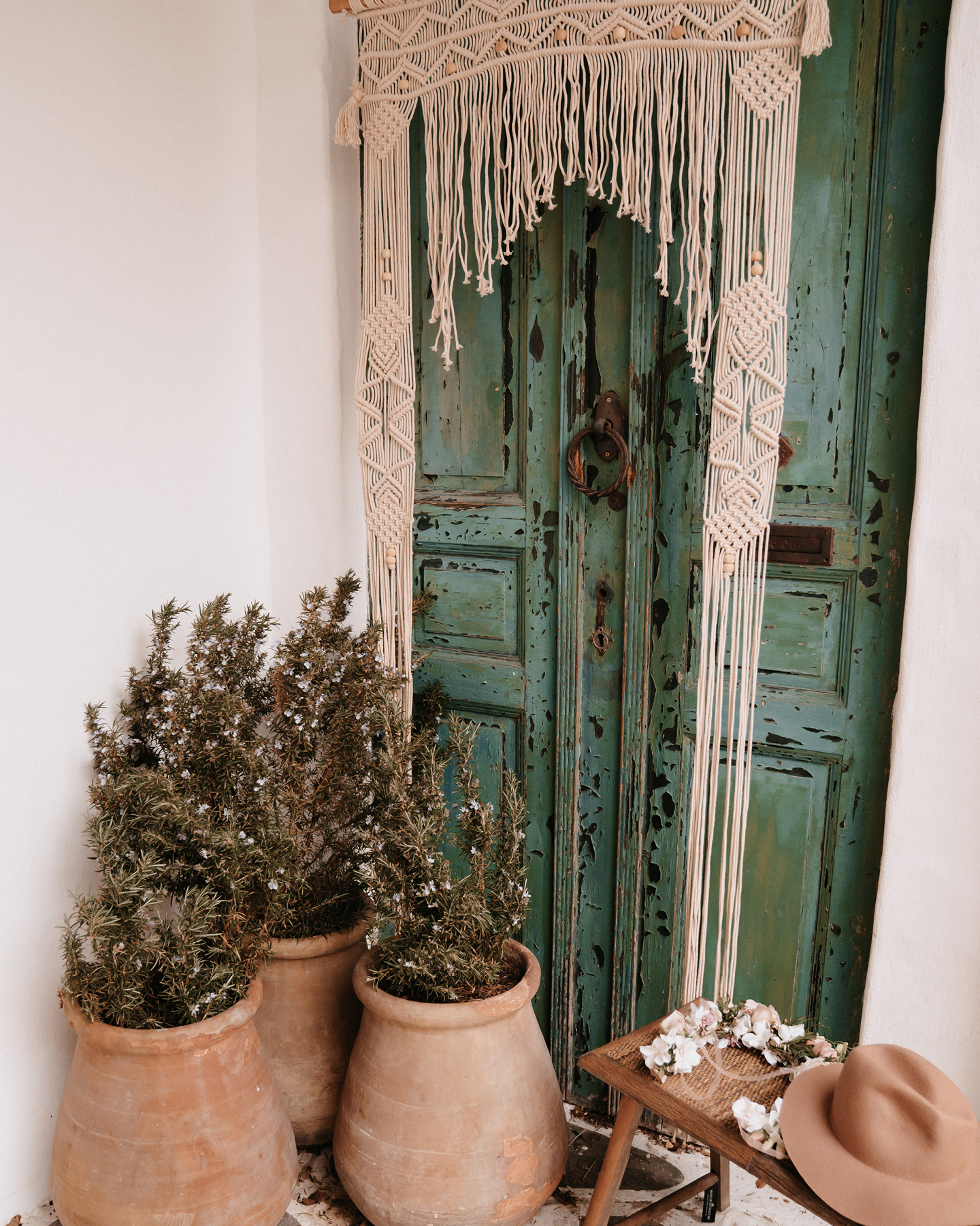 Aufwändig geknotete Makramee Boho Dekoration hängt an grüner Tür.
