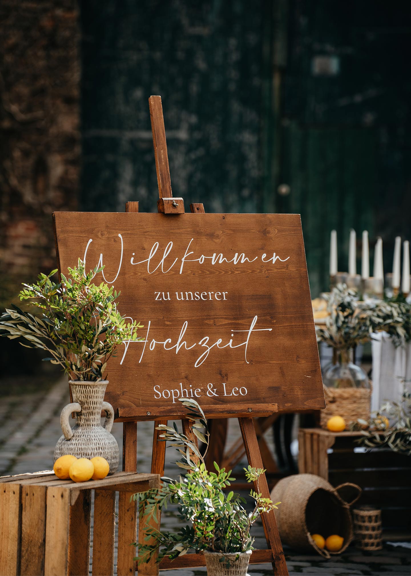 Hochzeitsschild aus Holz mit der Aufschrift "Willkommen zur Hochzeit" auf der dekorierten Scheunenhochzeit